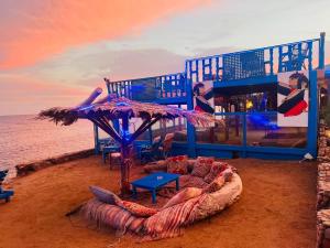 a building on the beach with a table and chairs at New Sphinx Resort in Dahab