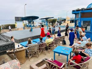 eine Gruppe von Personen, die vor einem Pool auf Stühlen sitzen in der Unterkunft New Sphinx Resort in Dahab + 9 Fotos