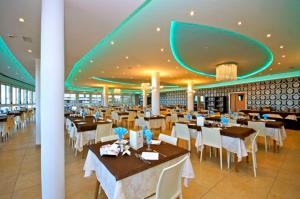 a restaurant with tables and white tables and chairs at Hotel Tibidabo in Bellaria-Igea Marina