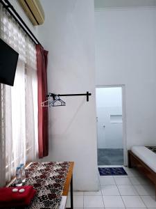 a room with a table and a shower and a door at Santalum Hotel Yogyakarta in Yogyakarta