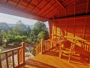 Una habitación con una mesa y sillas en un balcón. en Kastawa villa, en Sidemen