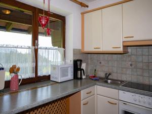 a kitchen with a sink and a microwave at Apartment in Hollersbach near Ski Slopes in Bramberg am Wildkogel