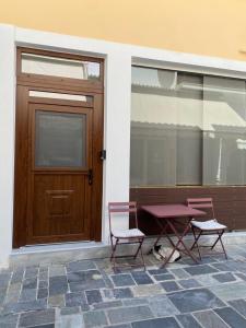 two chairs and a table in front of a door at Cosy Nest In Samos in Samos