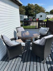 a patio with a table and chairs on a deck at Sunshine Lodge Haven Lakeland in Flookburgh