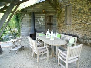 a wooden table and chairs with a fireplace on a patio at Holiday Home in Limoges with Saltwater Pool in Châteauneuf-la-Forêt
