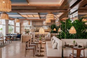 a restaurant with tables and chairs and potted plants at ME Marbella by Meliá in Marbella
