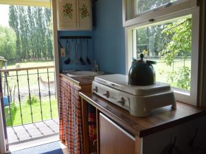 a kitchen with a stove and a sink and a window at Gypsy Caravan in Weideblick with Farm Animals in Bergen op Zoom