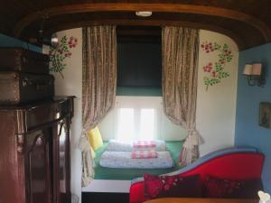 a bedroom with a bed in the corner of a room at Gypsy Caravan in Weideblick with Farm Animals in Bergen op Zoom