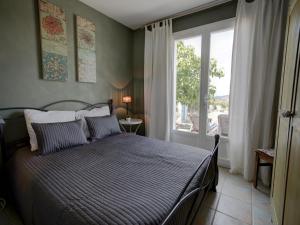 Un dormitorio con una cama y una ventana grande. en Stylish Family Villa in Félines, en Félines-Minervois
