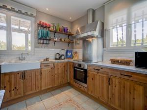 cocina con armarios de madera, fregadero y fogones en Stylish Family Villa in Félines, en Félines-Minervois