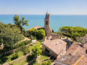 eine Luftansicht einer Kirche mit einem Turm in der Unterkunft Vecchio Forno Only Adult, Luxury, History, Comfort in Fiorenzuola di Focara