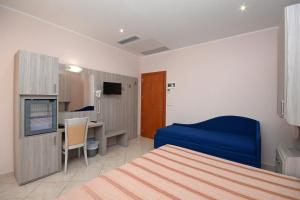 a room with a bed and a desk and a tv at Hotel Concorde in Cesenatico