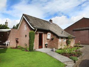 a red brick house with a green yard at Holiday Home in Margraten near Maastricht in Margraten