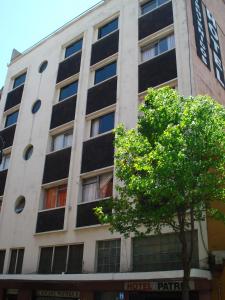 een gebouw met een boom ervoor bij Hotel Patria in Mexico-Stad