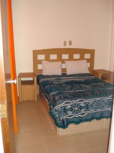 een slaapkamer met een bed met een deken en 2 kussens bij Hotel Patria in Mexico-Stad