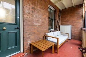 a porch with a bench and a green door at Millers Point Retreat 5 Min Walk to Barangaroo in Sydney +26 photos