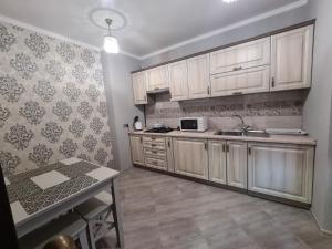 a kitchen with white cabinets and a sink and a table at Perinka in Polyana +14 photos