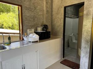 a bathroom with a sink and a shower with a toilet at Bantai Hideaway - House 1 in Baan Tai
