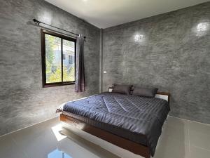 a bedroom with a bed and a window at Bantai Hideaway - House 1 in Baan Tai