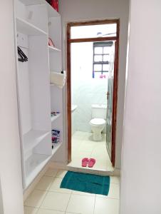 a bathroom with a toilet and a pair of flip flops at Wellys Serenity Haven in Kitengela 