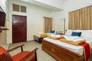 a hotel room with two beds and a television at Sri Ramakrishna Hotel in Bangalore +51 photos