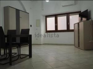 a room with chairs and a table and windows at TreDomus in Iglesias