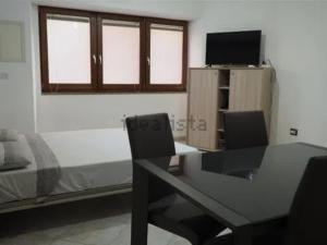 a room with a table and chairs and a bed at TreDomus in Iglesias