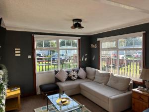a living room with a couch and two windows at Sunshine Lodge Haven Lakeland in Flookburgh