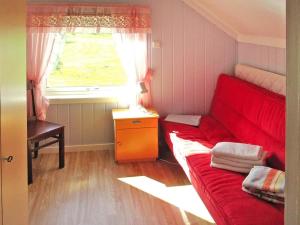 a small room with a red bed and a window at 7 person holiday home in Bøstad-By Traum in Alstad