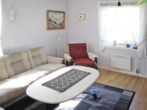 a living room with a couch and a chair at 7 person holiday home in Bøstad-By Traum in Alstad