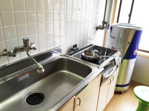 a kitchen sink with a pot on a stove at Toolate Guesthouse Toyama in Toyama