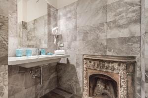 a bathroom with a stone wall and a fire place at Residenza D'Epoca Historia Luxury Boutique in Florence