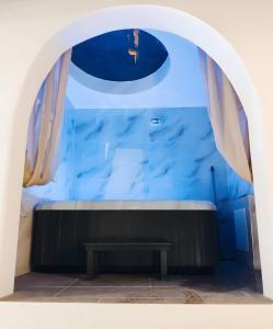 ein Torbogen mit einer Bank vor einer blauen Wand in der Unterkunft Mannas House in Émbonas