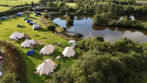 an aerial view of a group of tents next to a river at Kingfisher Bell Tent at Tregonetha Lake in Saint Columb Major