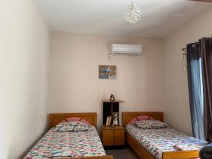 een slaapkamer met 2 bedden en airconditioning bij Travellers Room in Sarandë +9 foto's