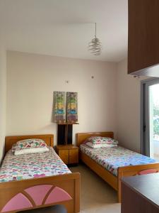 een slaapkamer met twee bedden en een raam bij Travellers Room in Sarandë