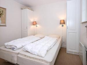a white bed in a room with two lamps at 4 star holiday home in Gjern in Gjern +15 photos