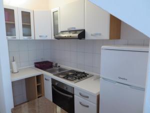 a white kitchen with a sink and a stove at Apartment Frano in Drače