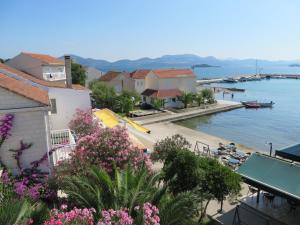 a view of the water and a town with pink flowers at Apartment Frano in Drače