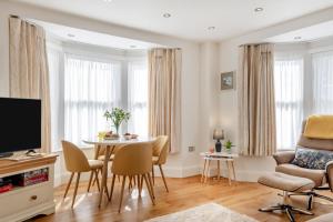 Una sala de estar con una mesa y sillas y un televisor. en 1 Bed in Freshwater oc-t32758, en Freshwater