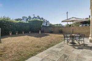 Un patio con una mesa y sillas y una sombrilla. en 1 Bed in Freshwater oc-t32758, en Freshwater