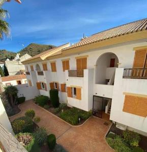 a large white house with brown doors and a courtyard at El cosy de Portman in Portman