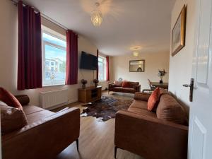 a living room with two couches and a tv at Posh Wetheringsett in Milton Keynes in Milton Keynes