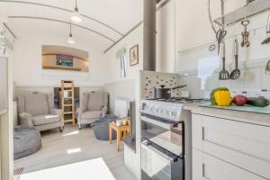a kitchen with a stove top oven next to a living room at 1 Bed in Baconsthorpe oc-b32691 in Baconsthorpe