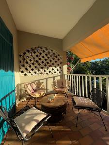 a patio with chairs and a table on a porch at Villa KazAlizés avec Piscine et Jardin Saint Leu in Saint-Leu