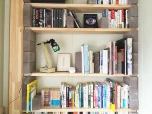 a book shelf filled with lots of books at Toolate Guesthouse Toyama in Toyama