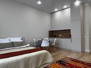 a bedroom with a bed and a table and chairs at Апартаменты Aktau Rivera in Aktau