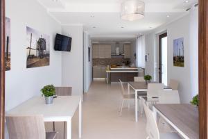 jadalnia i kuchnia z białymi stołami i krzesłami w obiekcie B&B Olganna w mieście Vasto