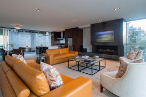 クイーンズタウンにあるVilla De Luxe, a Relax it's Done luxury holiday homeのリビングルーム(オレンジ色の家具、暖炉付)