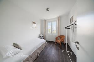 ウィーンにあるQuiet city oasis for up to 5 guestsのベッドと椅子と窓のある寝室 +11枚の写真